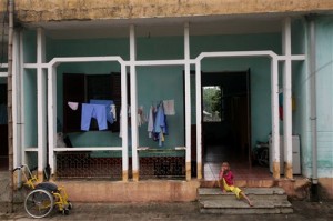 A physically and mentally disabled child sits on the steps of a hospital ward at a "peace village" center in the village of Thuy An, Vietnam, which houses people suffering from illnesses and deformities associated with contact to dioxin in chemical defoliant Agent Orange on Tuesday, May 15, 2007. (AP Photo/David Guttenfelder)